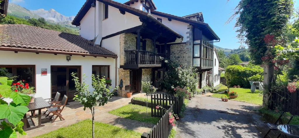 Fachada de El Caserío con balcón de madera y jardín